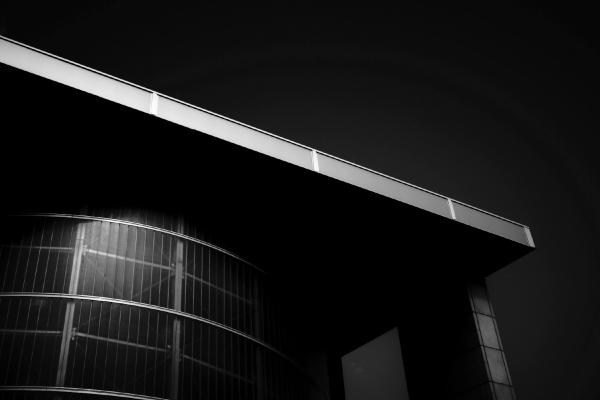 Nachtaufnahme moderner Architektur mit beleuchteten Gebäudeelementen gegen schwarzen Himmel