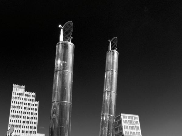 Zwei silberne Heliobus Light Pipes am Potsdamer Platz Berlin bei Nacht mit Hochhäusern